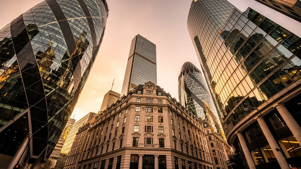 Dramatic perspective view of modern glass office towers in London's financial district with golden hour lighting reflecting off facades